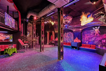 Interior of KitKat Club Berlin showing red seating, fetish-themed decor, and neon lights, illustrating the unique atmosphere described in the KitKat Club Review.