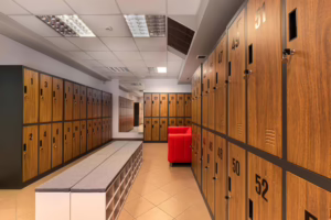 Spacious changing room with numbered wooden lockers and a red sofa inside Labirintus Swinger Club Budapest.