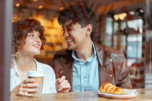 Partners smiling and talking over morning coffee, reconnecting after a swinger experience with emotional intimacy.
