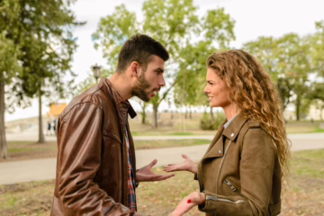 Couple having a serious conversation outdoors, representing communication and boundaries in open relationships