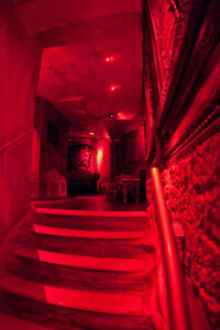 Red-lit staircase leading to play areas at Moon City Paris with intimate and moody atmosphere