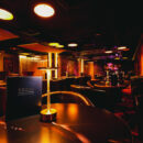 Social lounge at Swinger Club Paradiso with tables, ambient lighting, and relaxed atmosphere for conversation