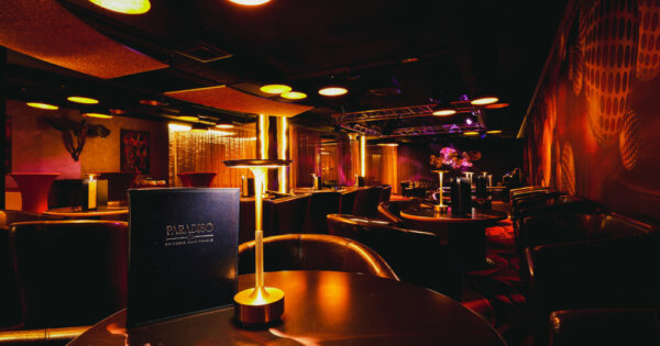 Social lounge at Swinger Club Paradiso with tables, ambient lighting, and relaxed atmosphere for conversation