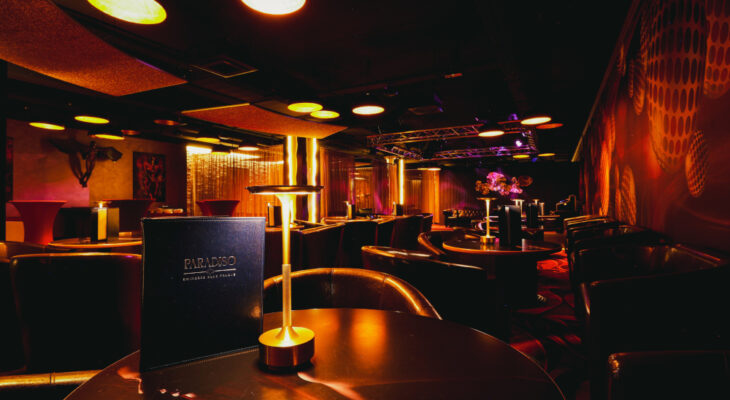 Social lounge at Swinger Club Paradiso with tables, ambient lighting, and relaxed atmosphere for conversation