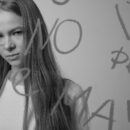 Woman looking serious through glass with words written on it, representing frustration from swinger dating mistakes and being ignored online