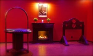 Themed room at Tucan Club Denmark with red lighting, fireplace, and specialized furniture setup