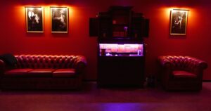 Lounge area at Tucan Club Denmark with leather sofas, warm red lighting, and intimate seating space