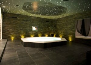 Spa area at Tucan Club Denmark featuring a central jacuzzi with ambient lighting and stone wall design