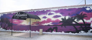 Exterior entrance and mural design of ATLANTIS Rivesaltes libertine club in southern France