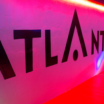 Stylish interior hallway and illuminated ATLANTIS signage inside the club