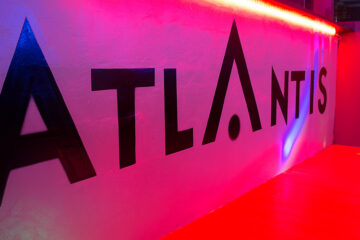 Stylish interior hallway and illuminated ATLANTIS signage inside the club