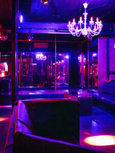 Stylish lounge and dance area inside Club Cocoon Brussels with purple lighting and luxurious seating
