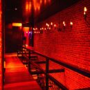 Red illuminated hallway inside Club Cocoon Brussels swinger club with exposed brick walls and elegant lighting