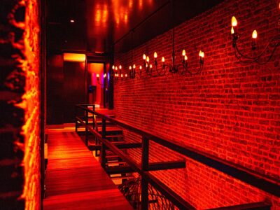Red illuminated hallway inside Club Cocoon Brussels swinger club with exposed brick walls and elegant lighting