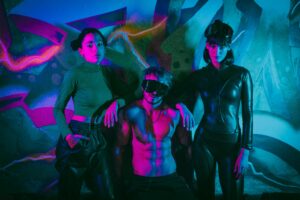 Group in futuristic fetish-inspired outfits showing the atmosphere of swinger vs fetish party culture