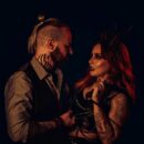 Couple in dark fetish-inspired styling representing the emotional overlap between swinger and fetish culture