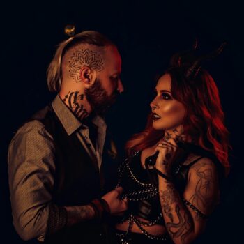 Couple in dark fetish-inspired styling representing the emotional overlap between swinger and fetish culture