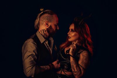 Couple in dark fetish-inspired styling representing the emotional overlap between swinger and fetish culture