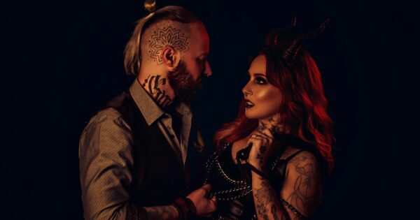 Couple in dark fetish-inspired styling representing the emotional overlap between swinger and fetish culture