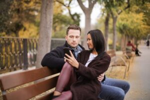 Couple reviewing an online dating profile together while looking for warning signs of fake swinger profiles.