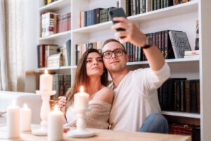Couple taking a selfie together as a safe way to verify identities and avoid fake swinger profiles before meeting.