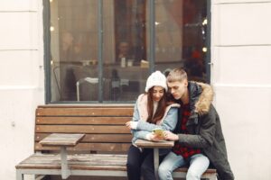 Couple chatting on a dating app before meeting in person, showing the importance of building trust and avoiding fake swinger profiles.