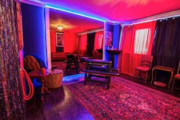 Red and purple BDSM room with bondage furniture and mirrors inside Lillith Club near Munich