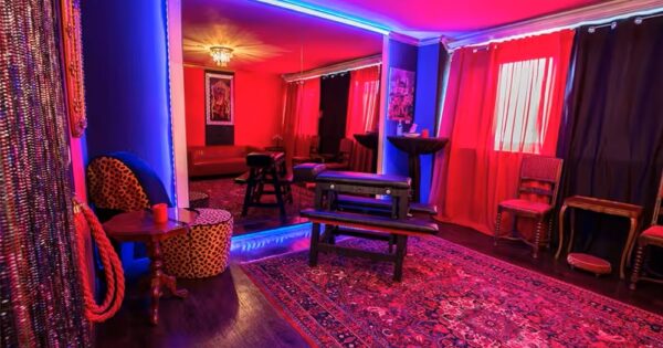 Red and purple BDSM room with bondage furniture and mirrors inside Lillith Club near Munich